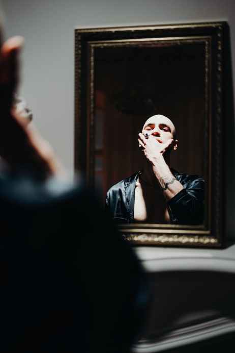 man looking at the mirror in holding his face